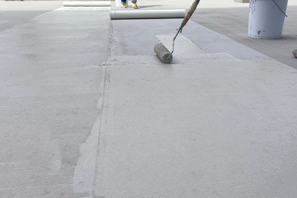 person using a roller to apply a smooth layer of coating on concrete floor during renovation 3 techniques for perfect finish