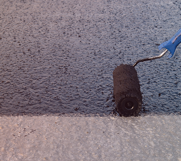 Paint roller applying black coating to surface with texture and finish enhancements for effective coverage in three stages