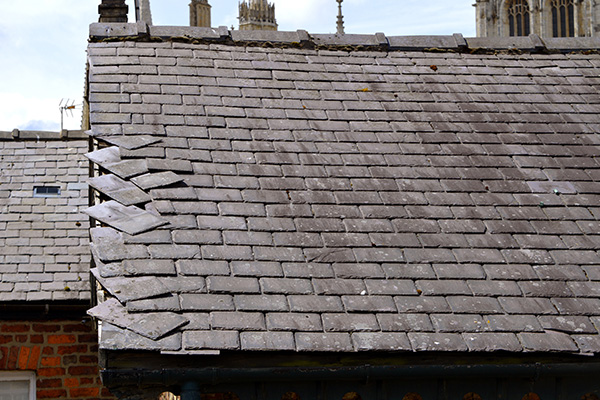 damaged roof shingles with uneven tiles in need of repair and maintenance three roofing solutions
