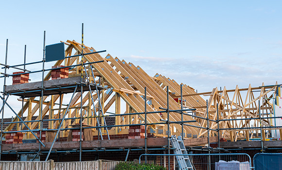 construction site with wooden roof framework and scaffolding showcasing 5 stages of building progress