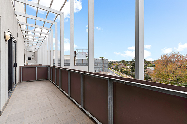 spacious balcony with railing and scenic view of trees and buildings under blue sky ideal for 12 outdoor relaxation activities