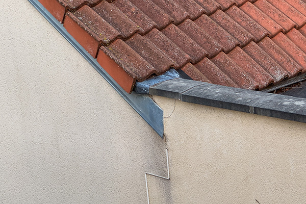roof intersection showing clay tiles and concrete surface with visible wear and moss potential issues in roofing maintenance for six year lifespan