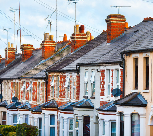 brick residential houses in a row with chimneys and antennas showcasing seven distinct styles and colors